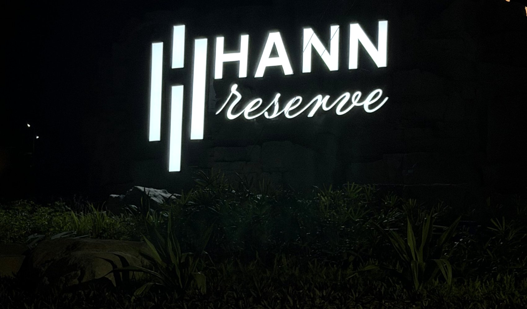 Hann Reserve entrance signage illuminated at night on the rock formation