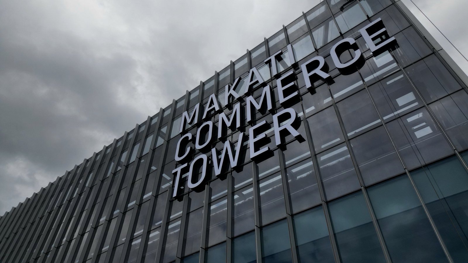Makati Commerce Tower facade lettering seen from street level