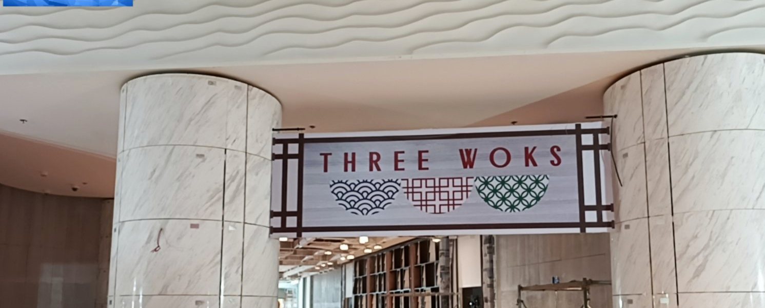 Three Woks sign installed between marble columns during fit-out
